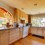 Notice the grand arched opening to the dining room from this sunny remodeled kitchen